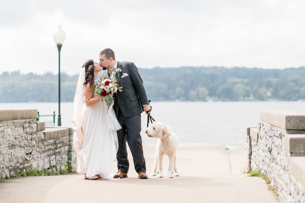 bride and groom kissing with dog