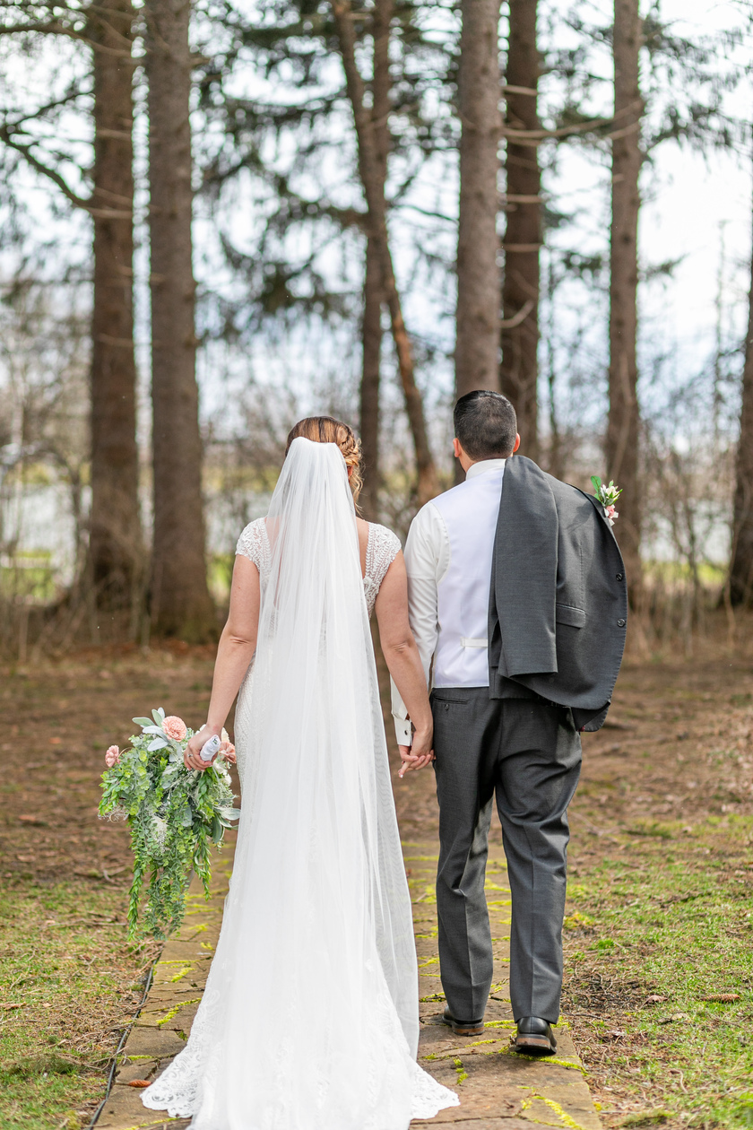 bride and groom walking away from the camera in the woods taken by a Upstate NY Wedding Photographer