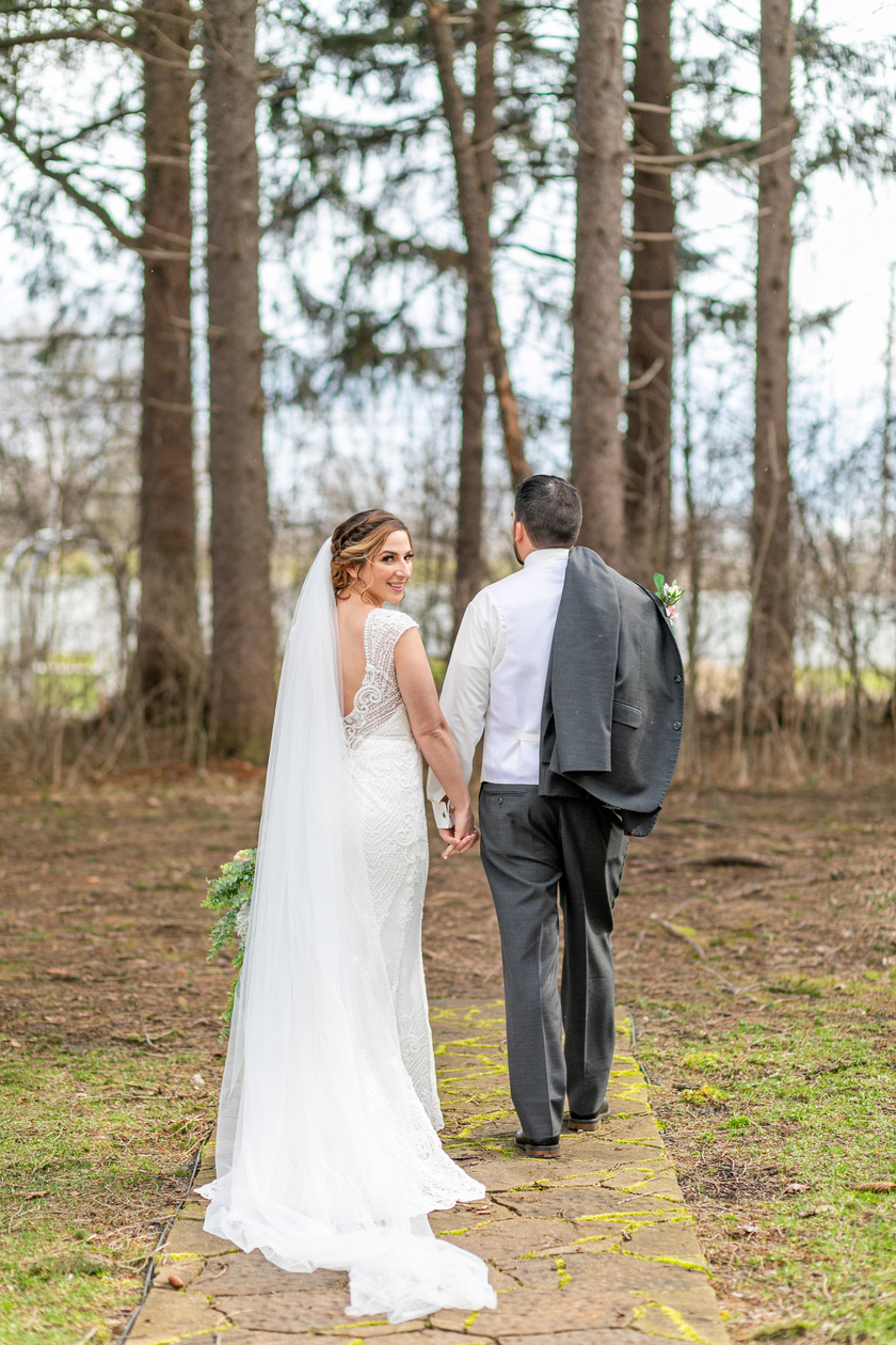 bride and groom walking away from the camera in the woods taken by a Upstate NY Wedding Photographer