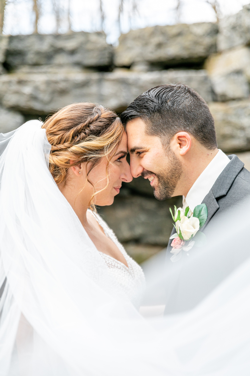 bride and groom touching foreheads with veil