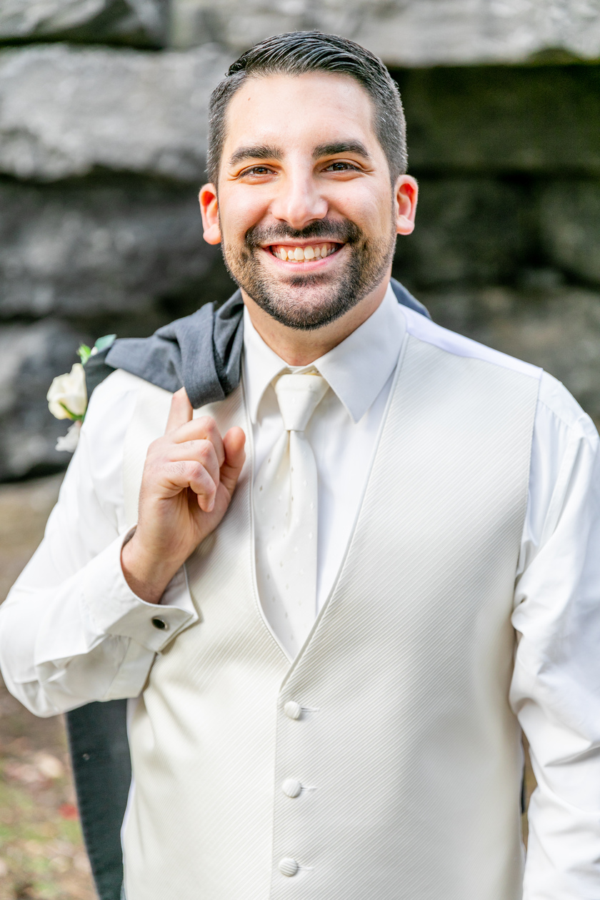 groom holding jacket looking at camera taken by a Upstate NY Wedding Photographer