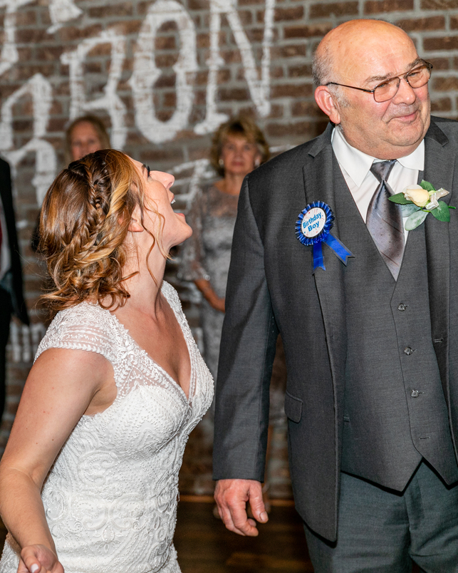 bride laughing with dad during reception