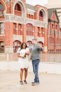 Couple spraying a bottle of champagne taken by a Syracuse NY Photographer