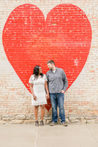 Couple in front of heart looking at each other taken by a Syracuse NY Photographer
