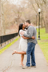 Couple kissing while woman pops foot up taken by a Syracuse NY Photographer
