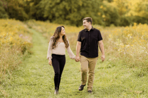 Couple walking through open fields at Camillus Unique Area engagement session